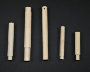 Five custom wood dowels with tenoned ends displayed on a black background, used for precision assembly in manufacturing.