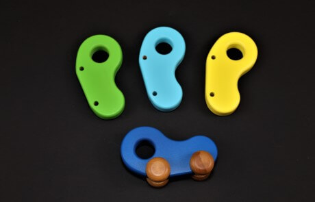 Three custom-shaped wooden toy parts CNC routed from natural hardwood for bulk manufacturing.