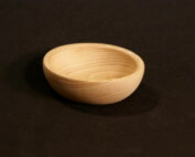 Custom small turned wooden bowl made from light-colored hardwood, displayed on a neutral background.