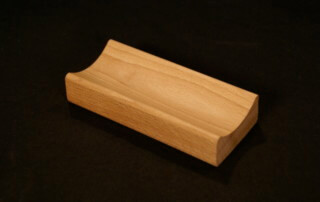 Single piece of small custom wood moulding made from light-colored hardwood for bulk production needs.