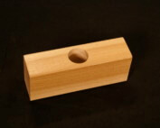 Custom moulded wood block with a precision-drilled hole for specialized applications.