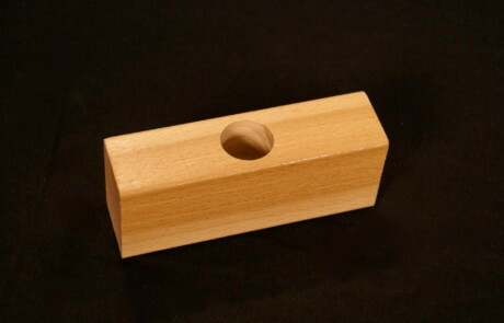 Custom moulded wood block with a precision-drilled hole for specialized applications.