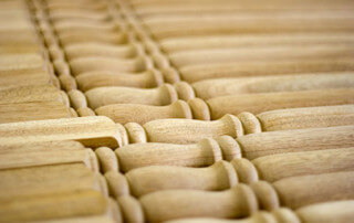 Multiple turned wood balusters laid out for inspection, each with unique profiles and smooth finishes.