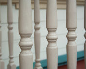 Custom turned wooden spindles displayed in a row, commonly used as balusters or furniture components.
