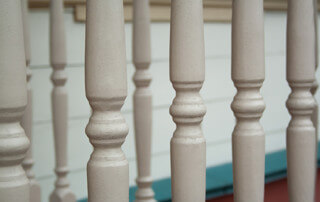 Custom turned wooden spindles displayed in a row, commonly used as balusters or furniture components.