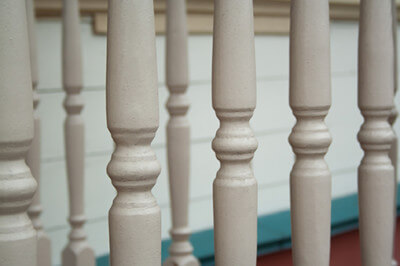 Custom turned wooden spindles displayed in a row, commonly used as balusters or furniture components.