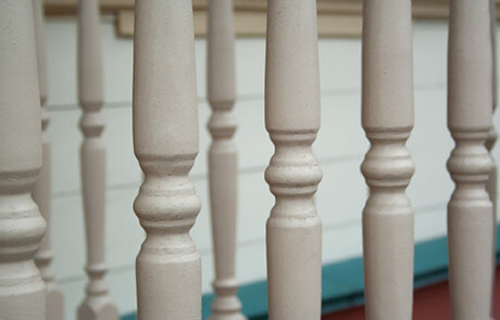 Custom turned wooden spindles displayed in a row, commonly used as balusters or furniture components.