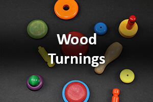 Assorted custom wood turnings with painted and shaped finishes, designed for high-volume manufacturing.