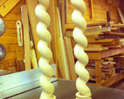 Two custom wooden porch posts with spiral rope twist design, shown upright.