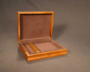 Custom wooden box with a hinged lid, felt-lined interior, and precision-cut inserts for secure item placement.