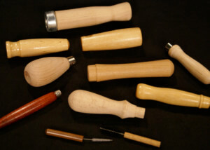 Assorted small wood tool handles in birch and maple with drilled ends and custom finishes.