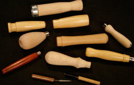 Assorted small wood tool handles in birch and maple with drilled ends and custom finishes.
