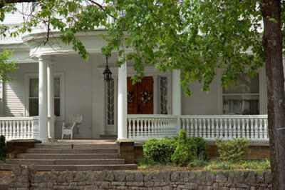 Wood porch columns shown that make up a front porch, as well as wood balusters and rails.