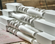 White paint-grade wood stair balusters for an interior railing.
