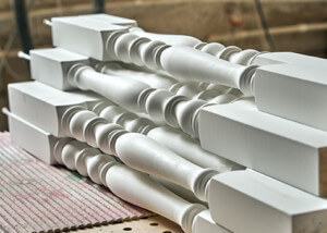 White paint-grade wood stair balusters for an interior railing.