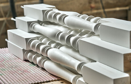 White paint-grade wood stair balusters for an interior railing.