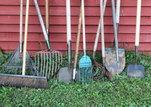 Wooden agricultural tool handles displayed in a row, designed for various farming and industrial applications.