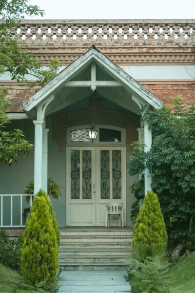 Photo of a house with wood porch columns and a door.